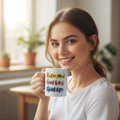 Woman holding a mug with motivational text in a bright room.